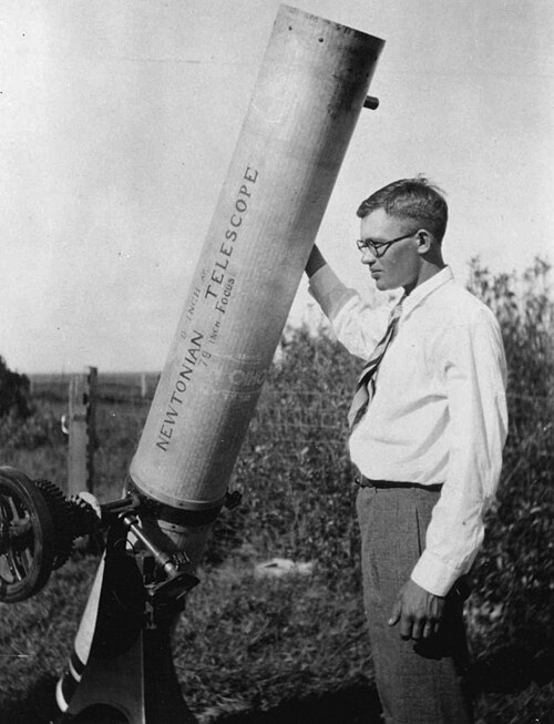 image shows a young Clyde Tombaugh with a telescope